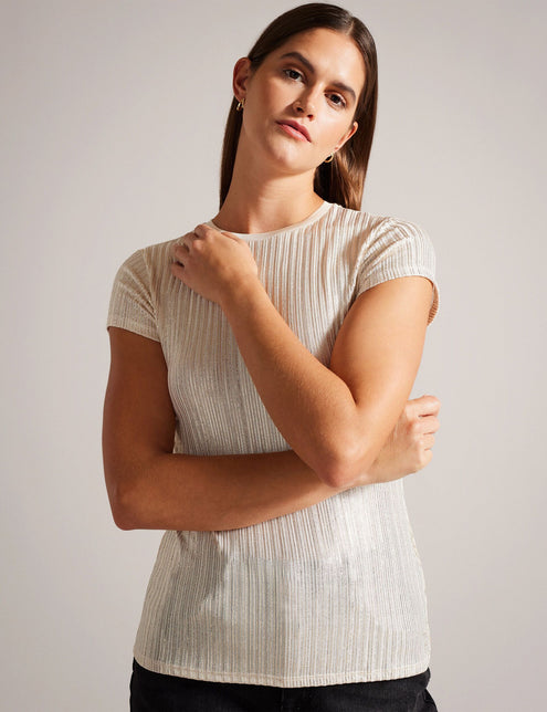 A woman wearing a gold ribbed t-shirt with metallic woven stripes and short sleeves.